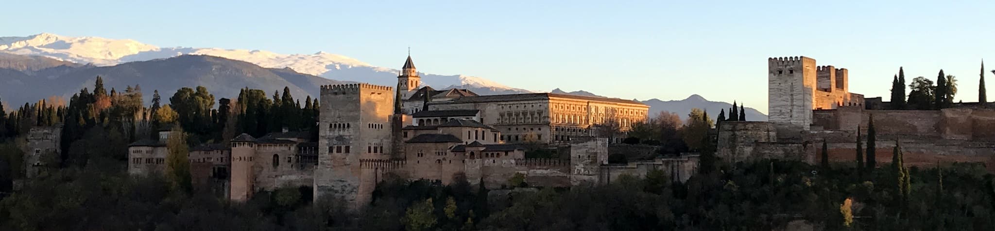 Kompleks istana Alhambra di atas bukit di Granada, Sepanyol, dengan gunung di belakangnya.