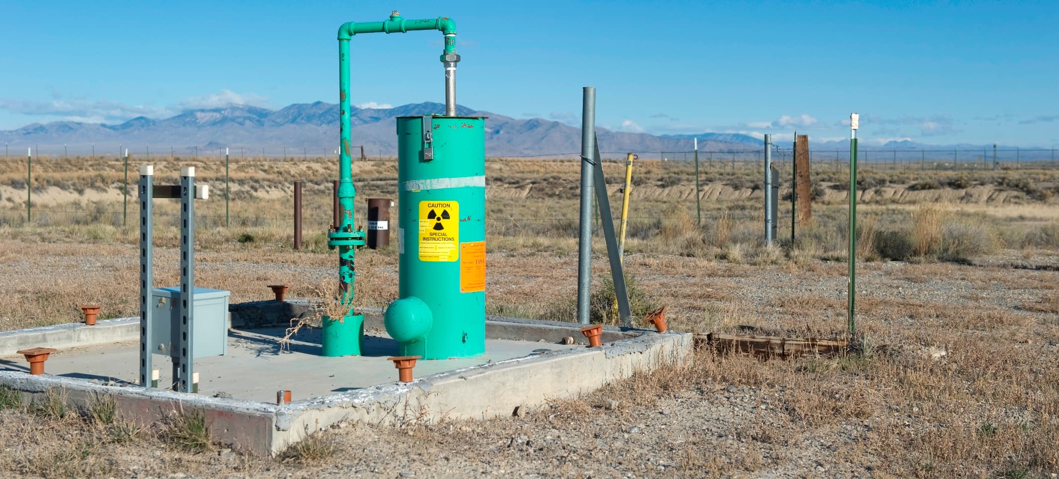 A field worker standing beside a groundwater injection well used for bioremediation at the Idaho National Laboratory site.