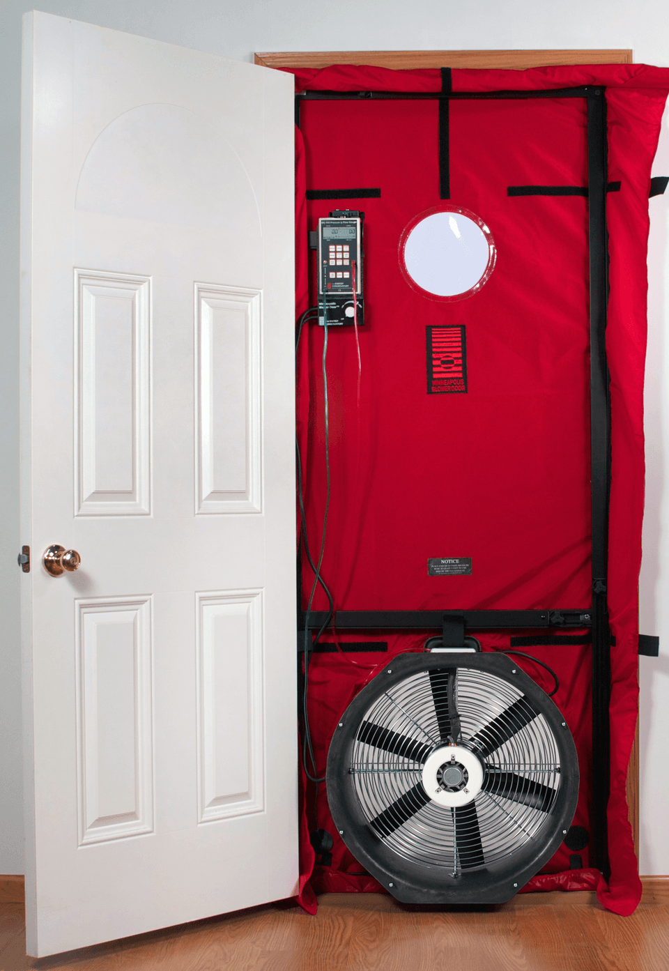 A calibrated blower door fan installed in an exterior doorway for building airtightness testing.