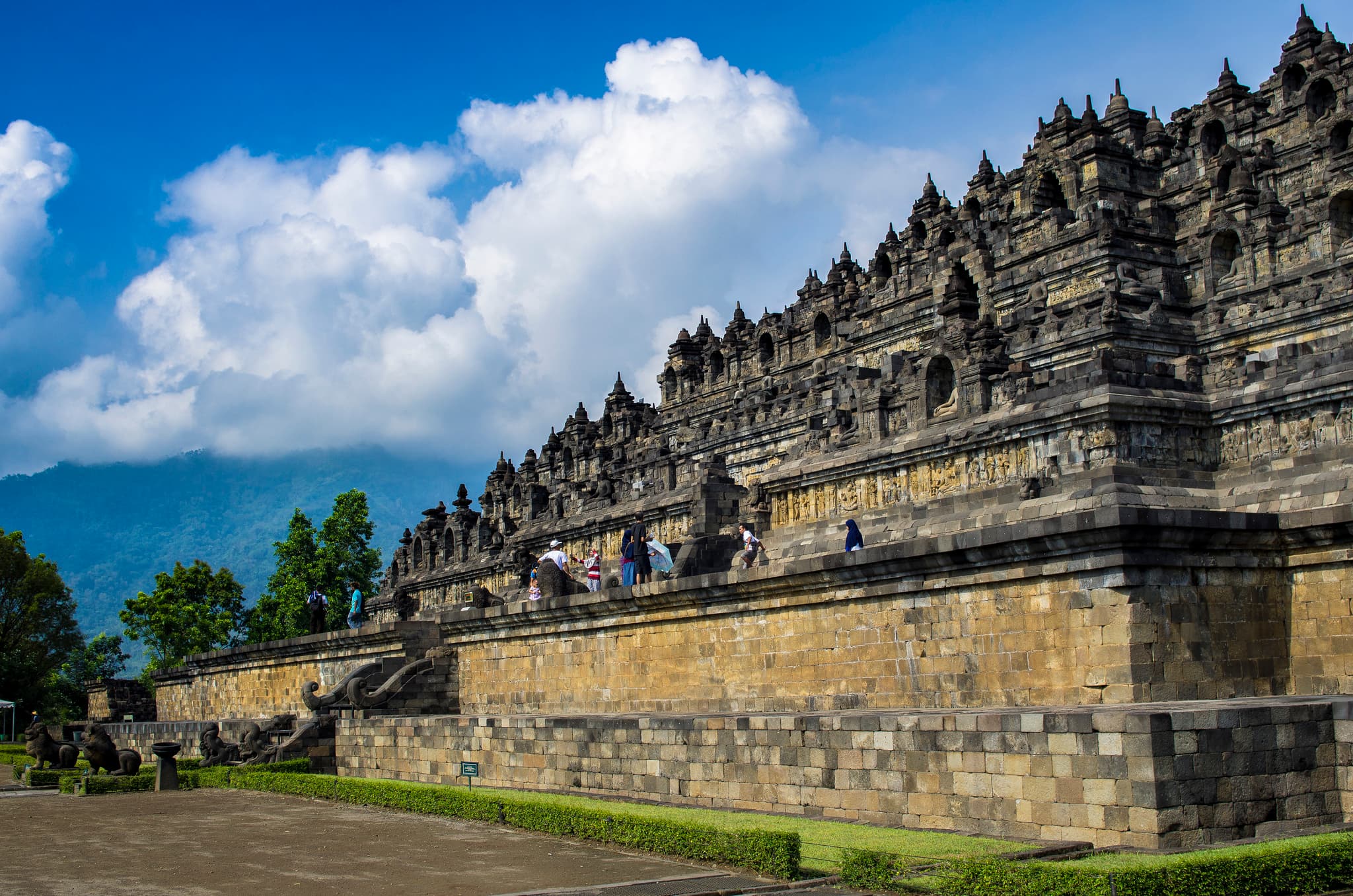 ប្រាសាទ Borobudur នៅកោះជ្វាកណ្តាល ដែលមានផ្ទៃរាបស្មើថ្ម ចេតិយ និងភ្នំភ្លើងនៅចំងាយ។