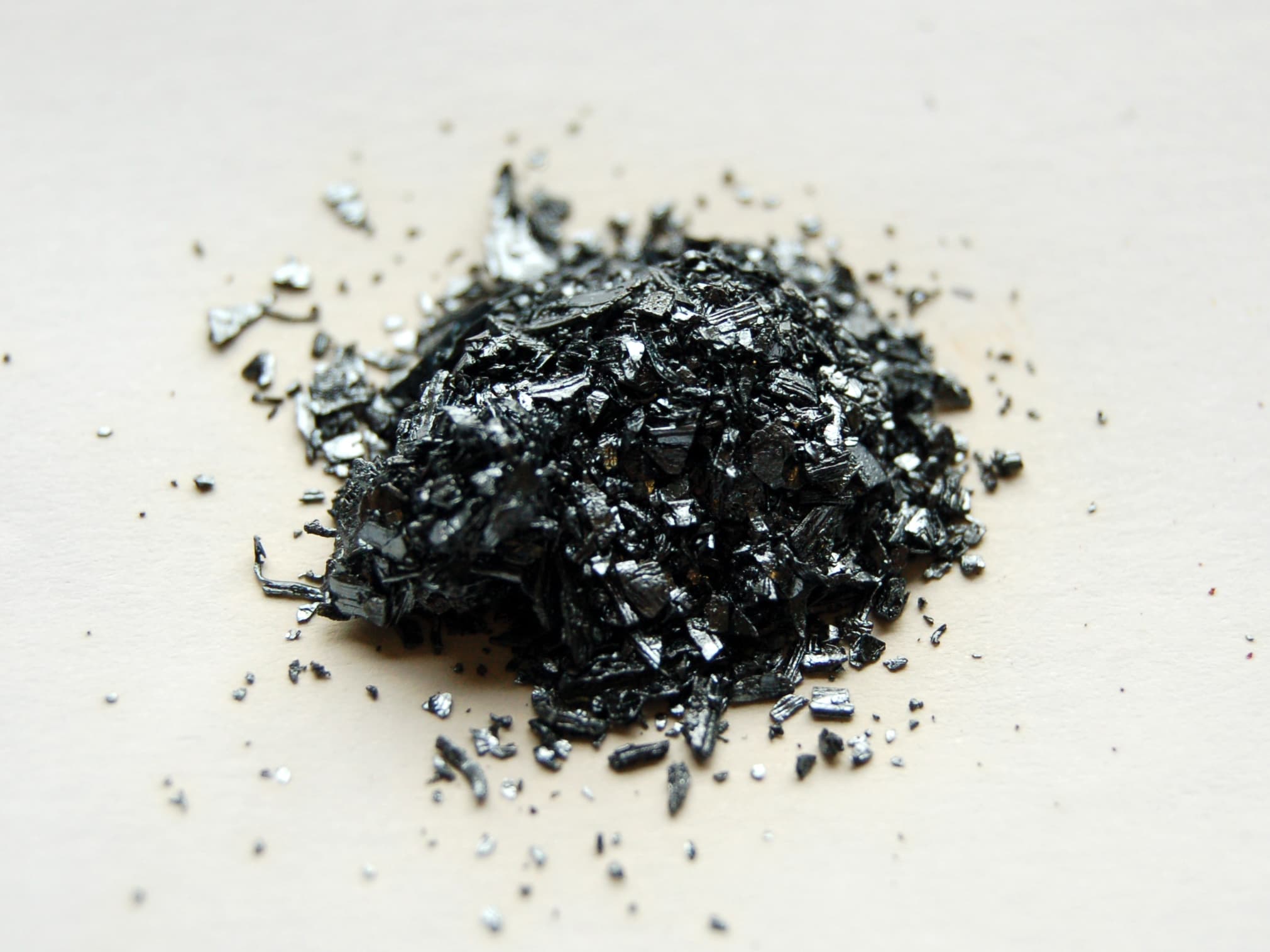 Dark crystalline iodine sample in a glass container.