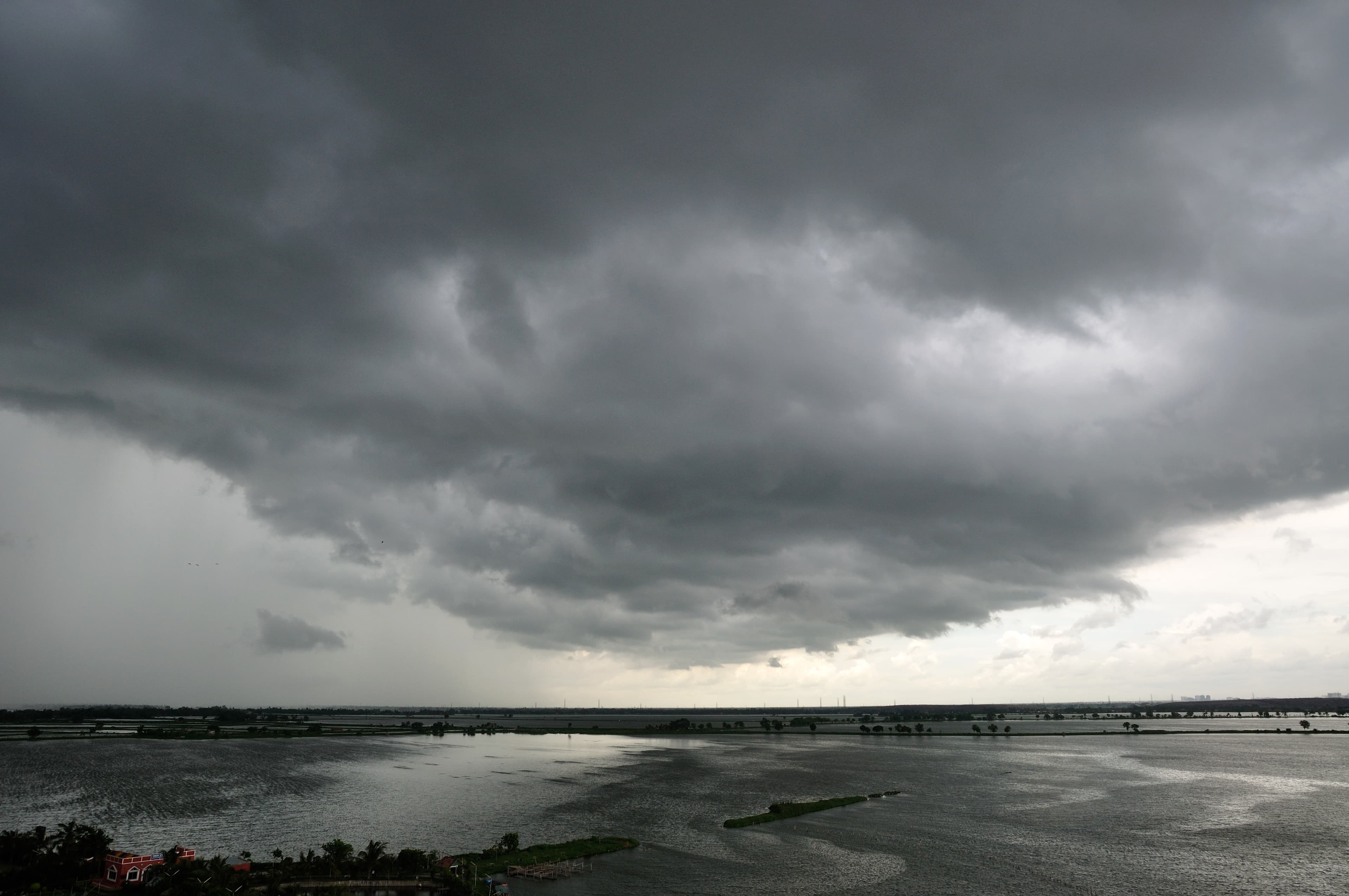 Dark monsoon clouds over wetlands near Kolkata, India, before rainfall.