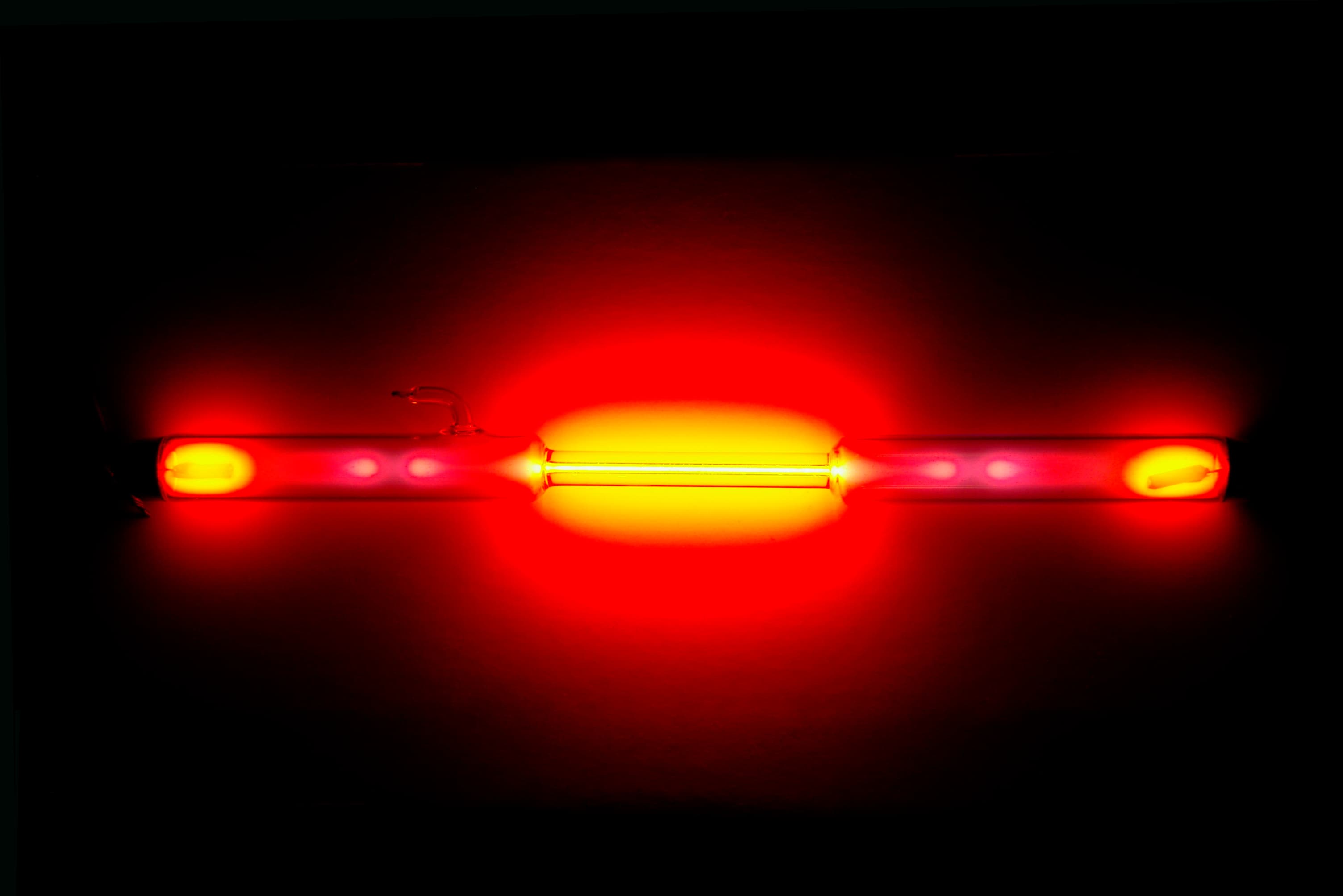 A neon gas discharge tube glowing reddish-orange.
