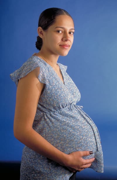 A pregnant patient sits during a clinic visit for pregnancy-related care.