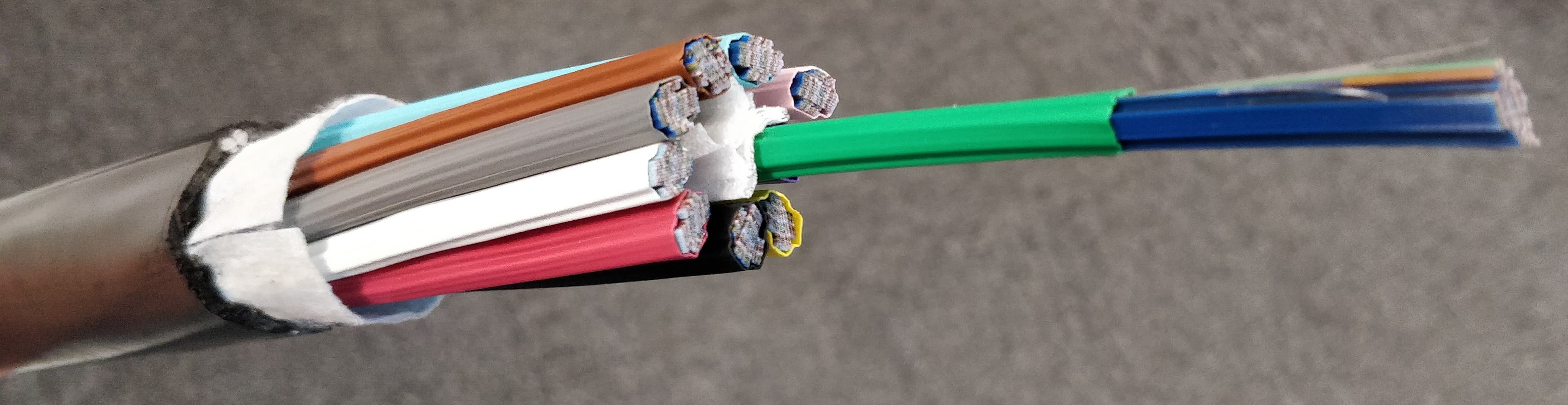Cutaway view of a ribbon optical fiber cable showing multiple colored fiber strands