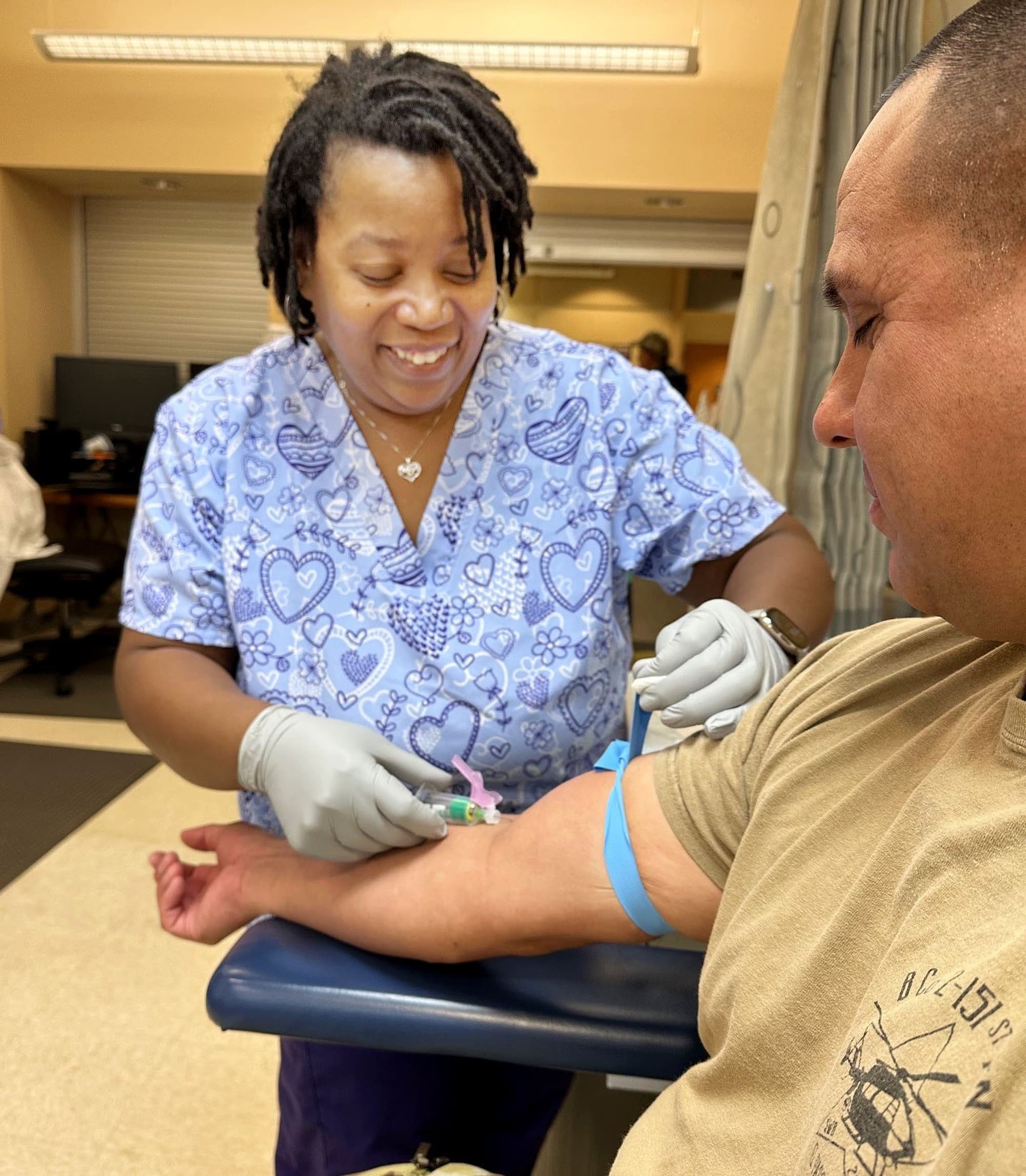 A phlebotomist collects a blood sample from a patient in a clinical laboratory setting.