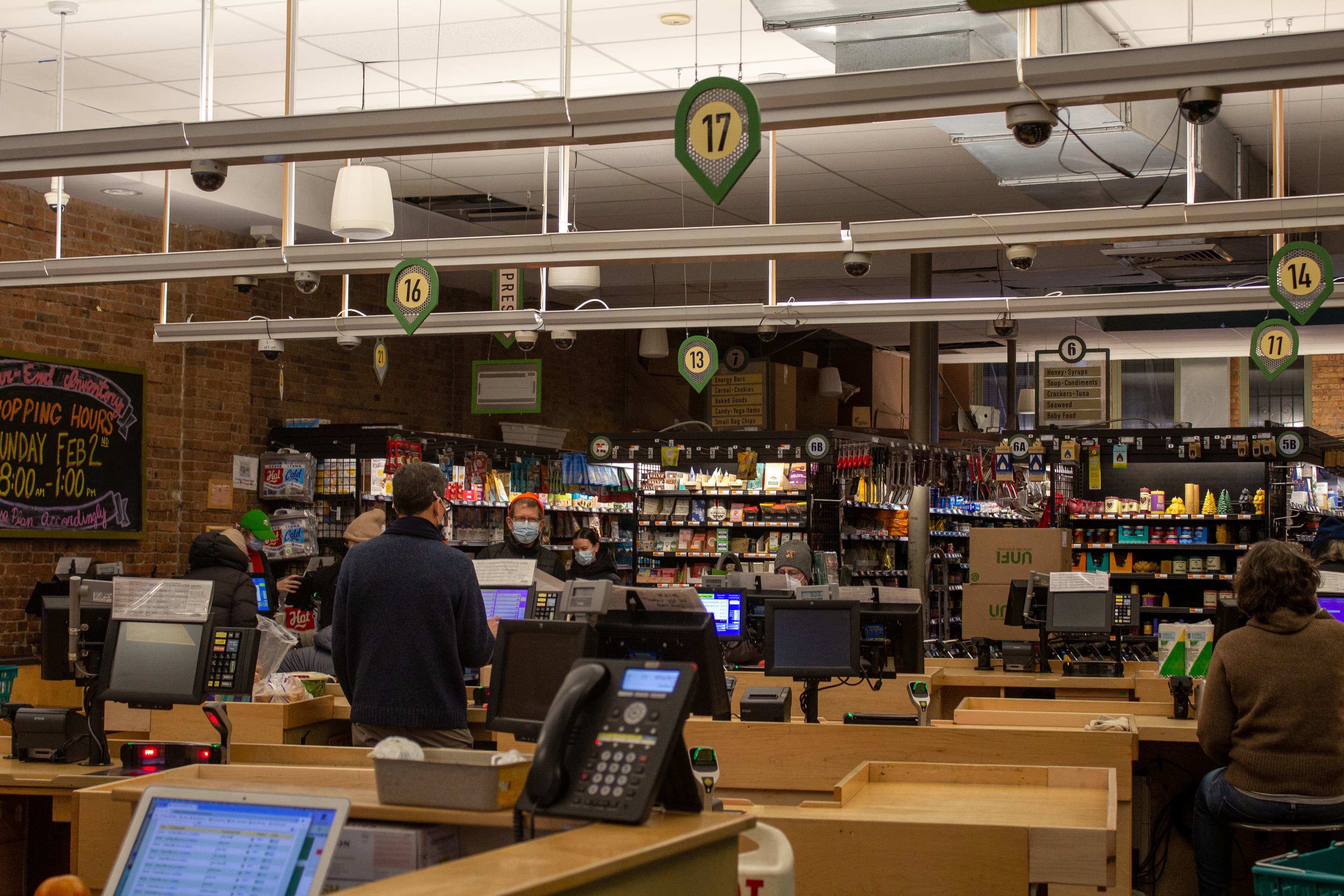 Interior of a food cooperative with shoppers and shelves of goods.