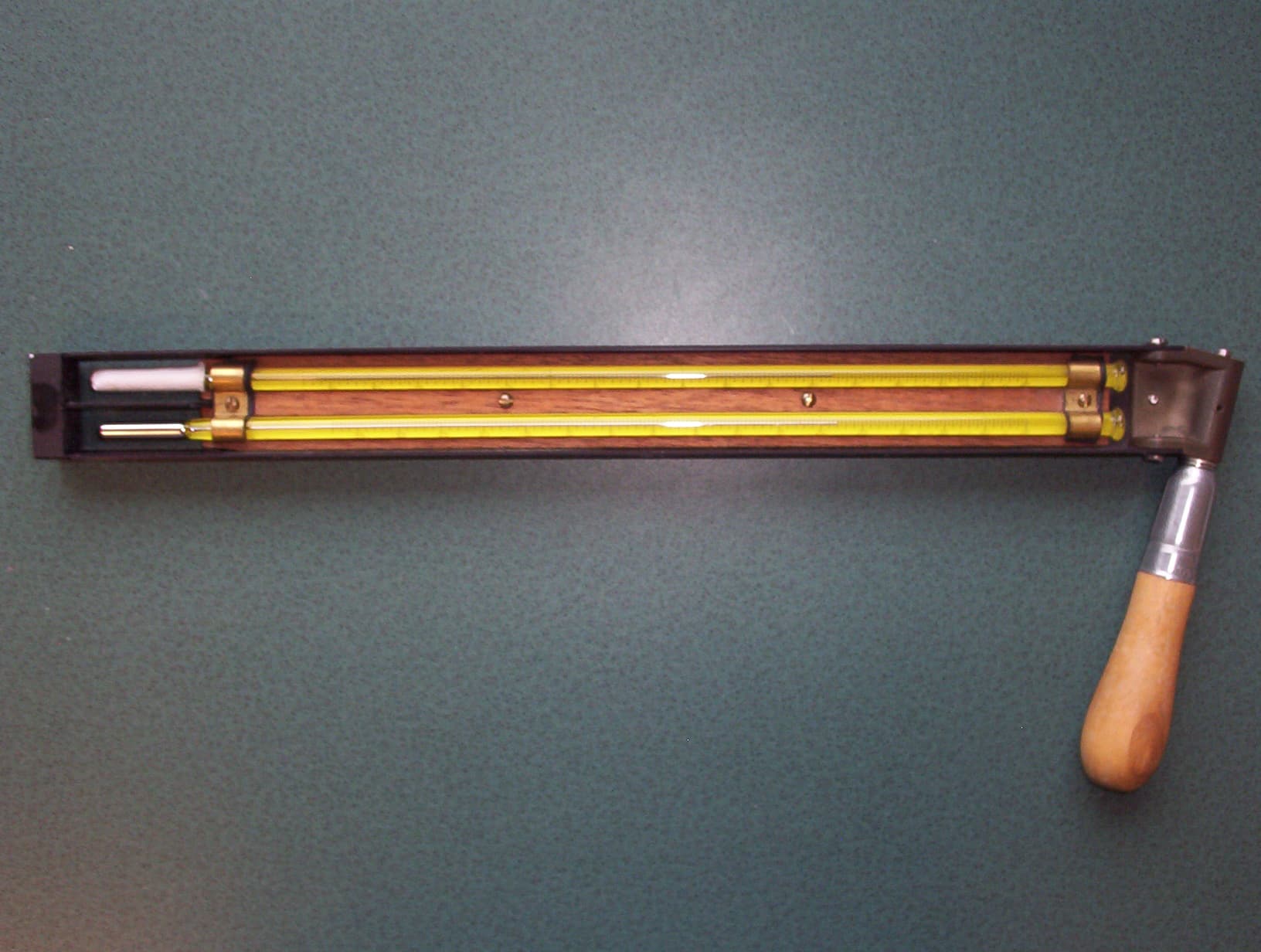 A sling psychrometer with paired thermometers, including a wet bulb used to measure evaporative cooling.